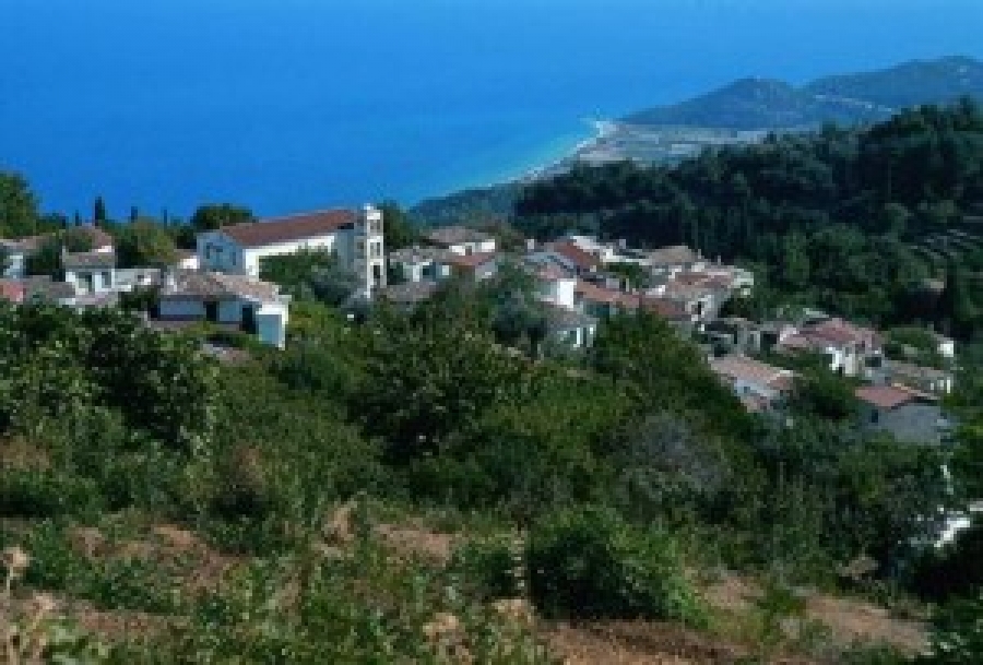 Aerial view of Stavrinides, Samos, with traditional houses and the sea in the background.