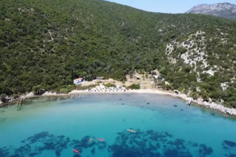 Παραλία Μεγάλη Λάκκα στη Σάμο με φυσική ακτή, πυκνή βλάστηση και καθαρά γαλαζοπράσινα νερά