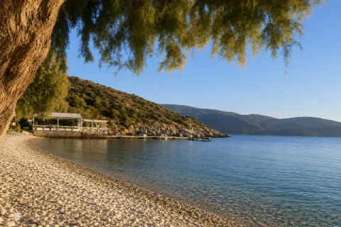 Spiaggia Klima a Samo con mare blu, alberi e paesaggio sereno sulla costa