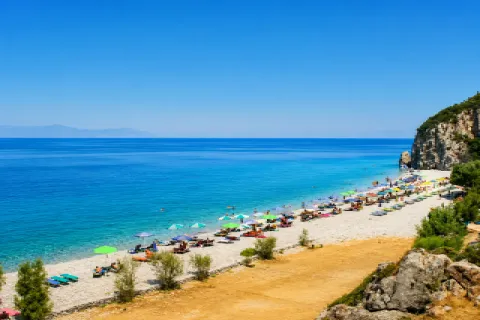 Παραλία Τσαμπού στη Σάμο με μεγάλα βότσαλα, βαθιά γαλάζια νερά και πεύκα γύρω από την ακτή