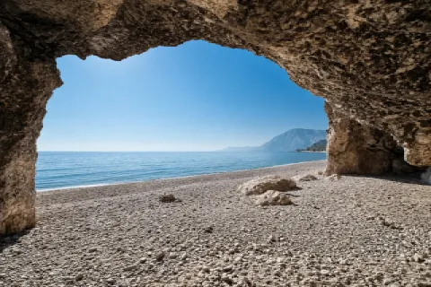 Spiaggia di Balos (Ormos Koumeikon) a Samo con ciottoli, acqua limpida e piccolo molo
