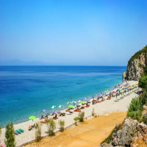 Παραλία Τσαμπού στη Σάμο με μεγάλα βότσαλα, βαθιά γαλάζια νερά και πεύκα γύρω από την ακτή