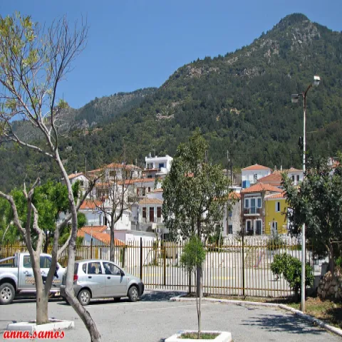 Deelzicht op Ydroussa op Samos vanaf de parkeerplaats, met huizen en helling.