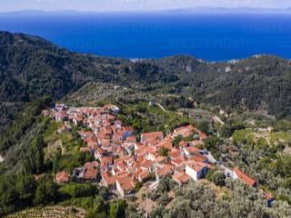 Steingassen und traditionelle Häuser in Manolates auf Samos, umgeben von Natur.