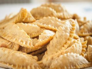 Traditionele kaltsounia uit Samos gevuld met ricotta, kaneel en honing op een bord geserveerd
